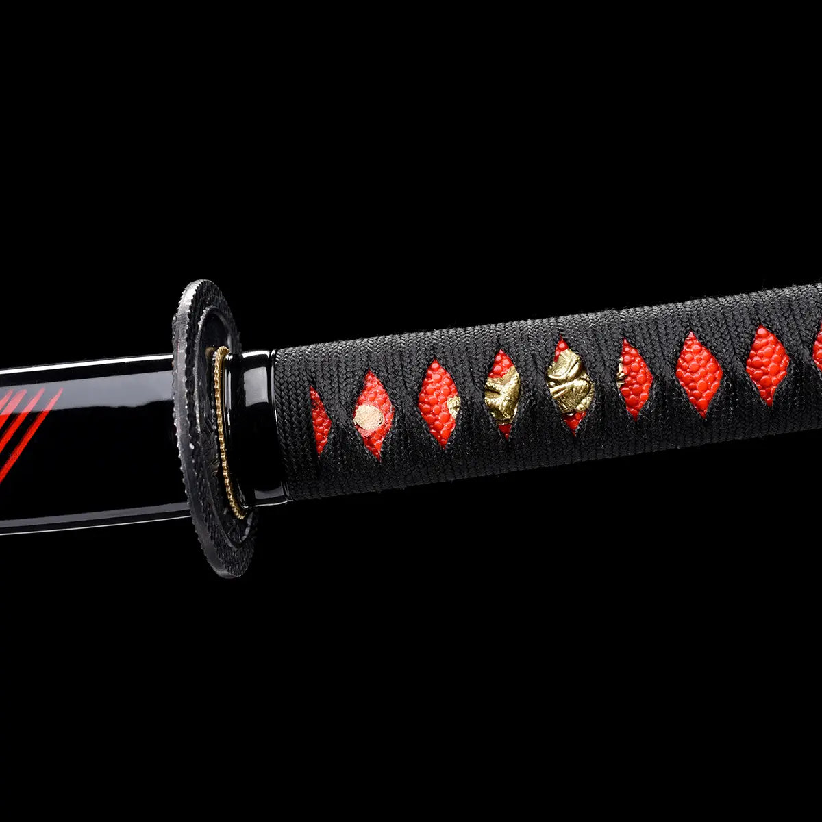 Gros plan sur la poignée tsuka du katana japonais Ryū Honō, tressage noir laissant apparaître un fond rouge samegawa et des ornements dorés en forme de dragon. Photo studio sur fond noir Blade Bushido, mettant en valeur la texture du cordage et les détails artisanaux du manche.