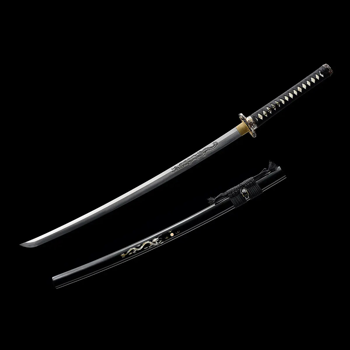 Katana japonais artisanal Ryū no Ken présenté dégainé sur fond noir profond, lame en acier courbée avec gravure dragon visible sur le plat, fourreau noir laqué placé en dessous avec motif dragon doré et cordon noir noué, manche noir tressé avec losanges blancs en peau de raie, garde ronde et habaki en laiton doré, absence de support, composition en diagonale mettant en valeur la lame et le saya.
