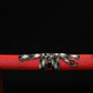 Close-up of Japanese katana Sakura no Ken saya, black background, red leather wrapped scabbard with textured surface, black and white woven sageo tied around the saya, detailed knot visible, traditional samurai sword mounting
