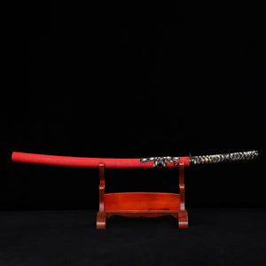 Japanese katana Sakura no Ken displayed horizontally on a wooden stand, black background, red leather wrapped saya with visible texture, katana fully sheathed, black and white tsuka ito wrapping, sageo tied around the saya, traditional samurai sword presentation
