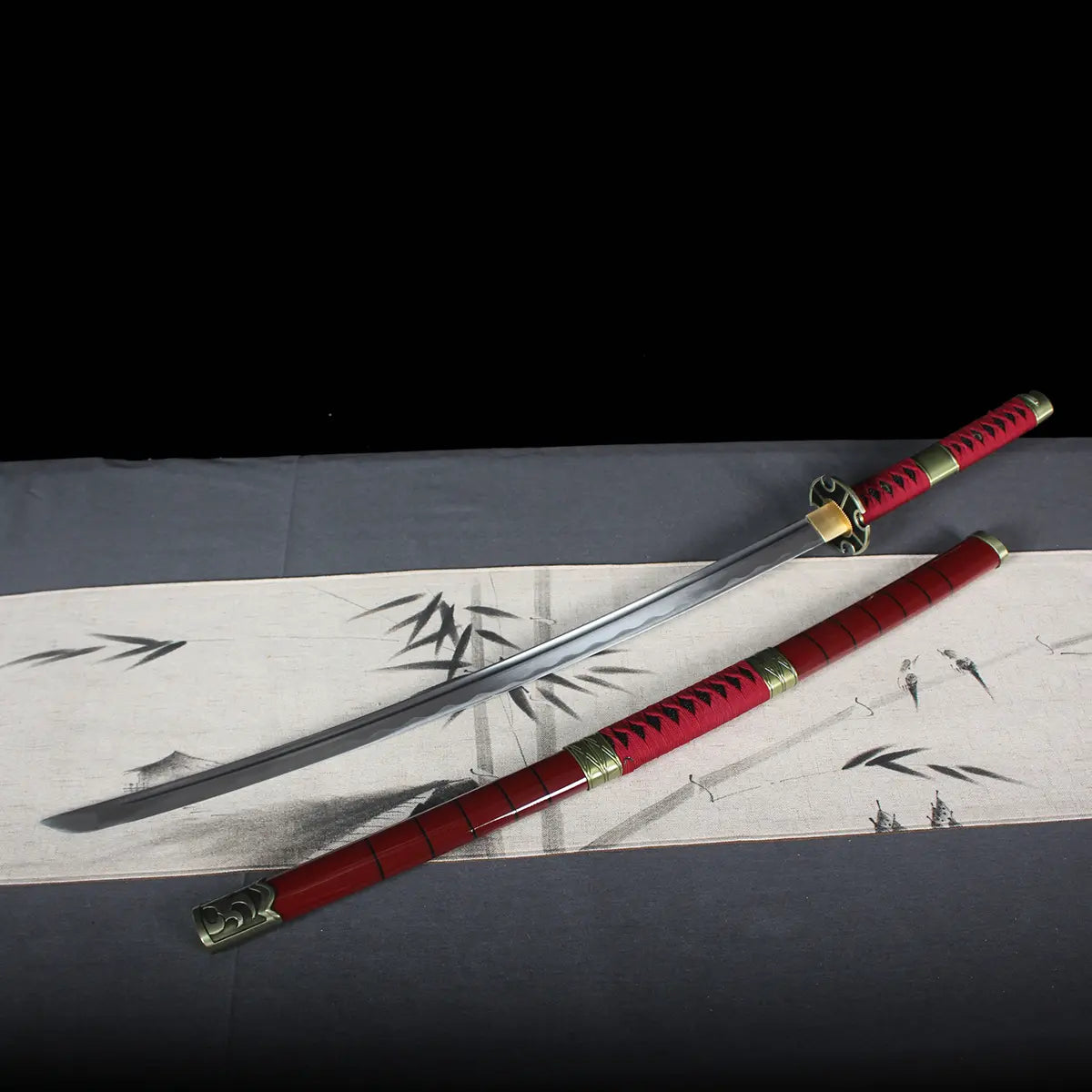 Katana Sandai Kitetsu One Piece entièrement dégainé avec lame brillante et fourreau rouge assorti, posé sur tissu japonais décoratif