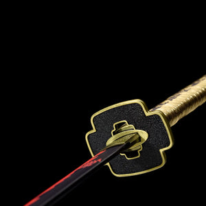 Gros plan de la tsuba dorée et du habaki du katana Tsugikuni Yoriichi, sabre Demon Slayer collector.