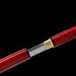 Détail rapproché du katana Zatoichi Lame du Vagabond, sabre japonais en acier carbone 1045 avec fourreau rouge laqué brillant et habaki doré, manche assorti, sur fond noir. Réplique authentique Blade Bushido idéale pour cosplay et collection
