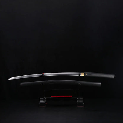 Katana shirasaya noir KUROTAKE avec la lame sortie du fourreau, présenté horizontalement sur un support sombre, fond noir uniforme, lame en acier poli visible avec courbure marquée, fourreau et poignée en bois dur laqué noir imitation bambou, habaki en laiton apparent, ensemble sans tsuba.
