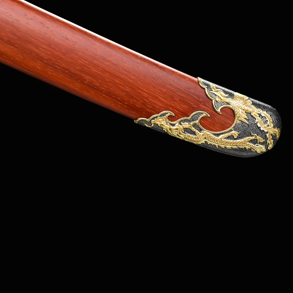 Gros plan sur l’extrémité du fourreau rouge-brun du sabre chinois Dao LONG FENG, avec texture bois visible, garniture noire et dorée ornée d’un dragon en relief, et fond noir sobre.
