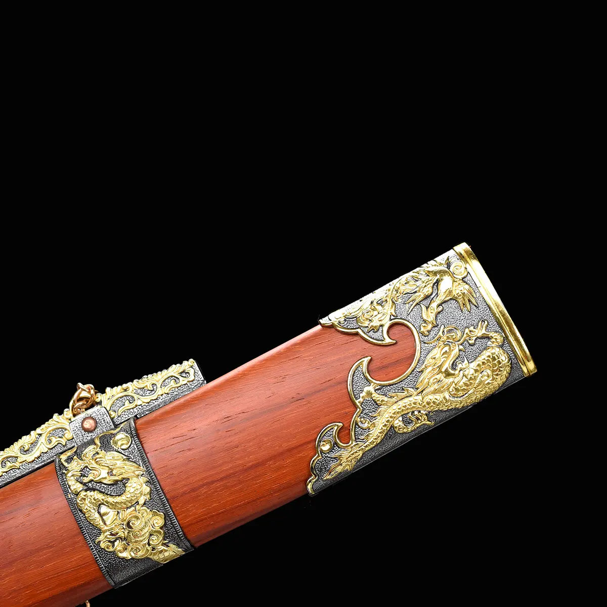 Gros plan sur le fourreau rouge-brun du sabre chinois Dao LONG FENG, avec texture bois visible, garnitures noires et dorées ornées de motifs dragon et phénix en relief, et fond noir sobre.
