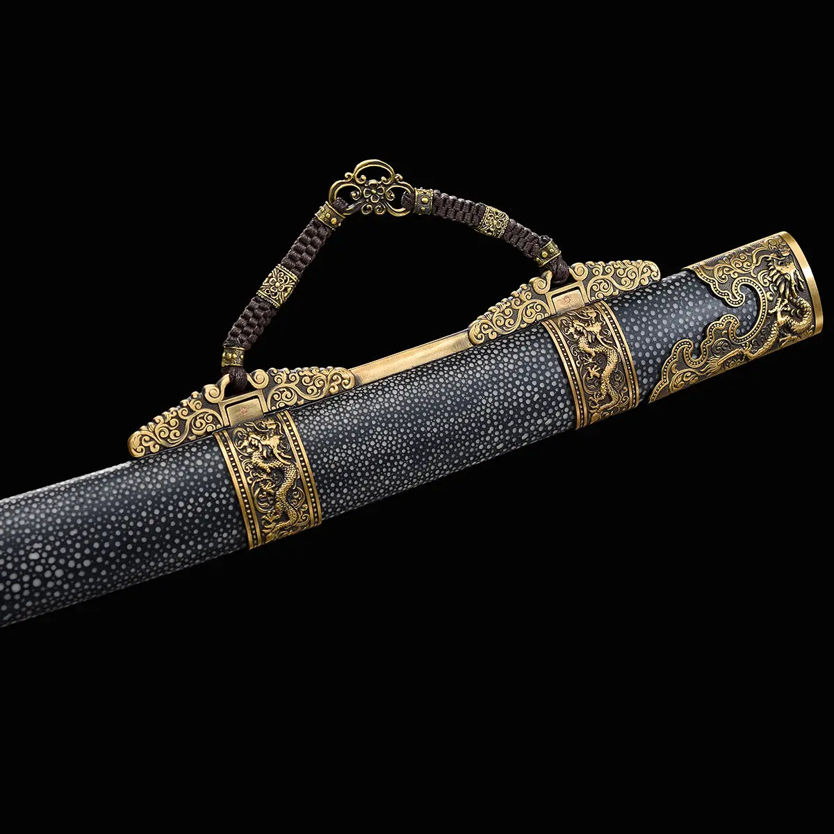 Gros plan sur le fourreau noir texturé du sabre chinois Dao LONG WEI, avec garnitures en laiton doré ornées de dragons, poignée de transport tressée brune, embout décoré et motifs métalliques visibles sur fond noir.