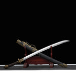 Sabre chinois Dao LONG WEI présenté sur un support en bois rouge, avec lame courbe argentée sortie du fourreau noir texturé, poignée brune tressée, garde ronde en laiton, pommeau décoré et garnitures dorées à motifs dragon sur fond noir.