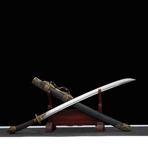 Sabre chinois Dao LONG WEI présenté sur un support en bois rouge, avec lame courbe argentée sortie du fourreau noir texturé, poignée brune tressée, garde ronde en laiton, pommeau décoré et garnitures dorées à motifs dragon sur fond noir.
