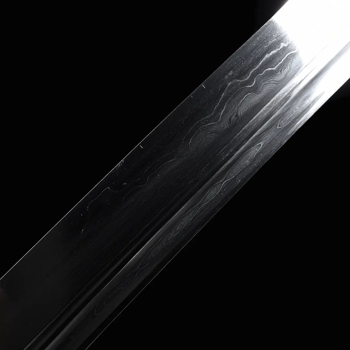 Gros plan sur la lame du sabre chinois Dao LONG WEI, avec reflets sombres sur fond noir, gorge centrale visible et motifs ondulés de l’acier plié sur la surface de la lame courbe.