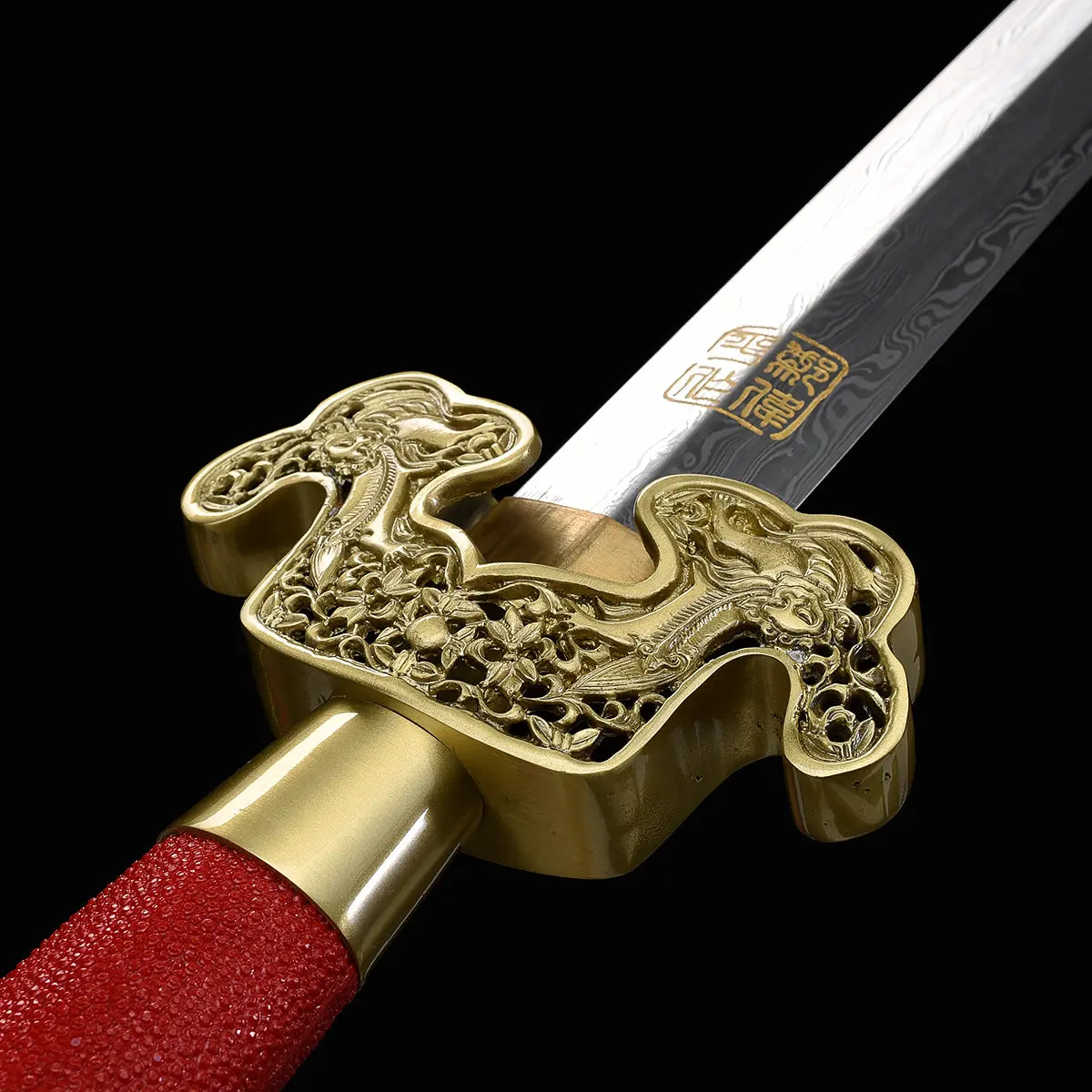 Gros plan sur l’épée chinoise Jian LONGQUAN HONG LONG avec garde dorée ouvragée, poignée rouge texturée, lame droite en acier plié et inscription dorée visible sur fond noir.