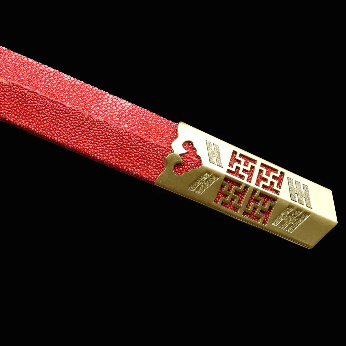 Gros plan sur l’extrémité du fourreau rouge texturé de l’épée chinoise Jian LONGQUAN HONG LONG, avec bouterolle dorée ornée de motifs géométriques et finition brillante sur fond noir.