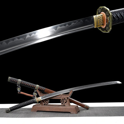 Composite image of the Japanese katana Meiyo on a solid black background, combining a close-up view of the polished T10 steel blade and a full presentation on a carved wooden display stand. The upper section highlights the real wavy hamon along the blade and the decorative brass habaki with cutout pattern near the tsuba. The lower section shows the katana displayed unsheathed on the wooden stand, with the dark brown wooden saya positioned beneath and the black tsuka wrapped in black ito over rayskin. The sc
