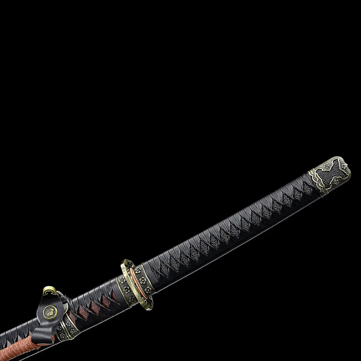 Close-up view of the Japanese katana Meiyo handle on a solid black background, focusing on the tsuka wrapped in black ito over black rayskin. The image shows the diamond-pattern wrapping texture, the metal fuchi and kashira with antique-style floral decoration, and part of the sageo cord attached near the handle. The handle is angled diagonally, with no blade or scabbard fully visible, highlighting the craftsmanship of the grip materials and traditional samurai mounting details.
