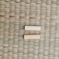 Deux mekugi en bambou clair posés parallèlement sur un tatami tressé beige, fond neutre ; extrémités rondes et surfaces lisses visibles, aucune lame ni fourreau présent. Accessoire mekugi bambou katana, HEMA AMHE, vue rapprochée.
