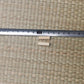 Deux mekugi en bambou clair posés sous une règle métallique graduée en millimètres, repère 10 cm visible, sur un tatami tressé beige ; aucune lame ni fourreau présents. Accessoire mekugi bambou katana, mesure 2–3 cm, HEMA AMHE.
