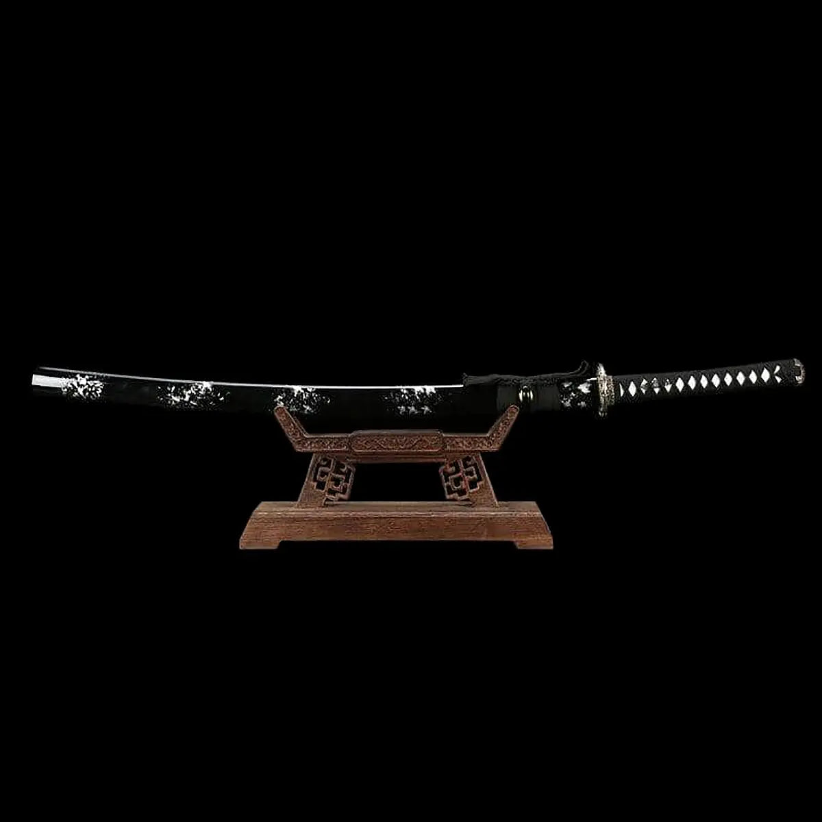 Japanese handmade katana Renge no Ken displayed on a wooden stand against a deep black background, black glossy saya with white lacquer splash patterns, katana fully sheathed, black tsuka wrapped with black cord over white ray skin, lotus motif tsuba in dark metal, traditional Japanese sword presented horizontally  
