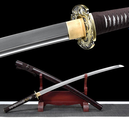 Detailed view of the Ryusei Japanese katana showing the unsheathed blade near the hilt, photographed against a solid black background. The polished steel blade emerges from a gold-colored habaki, revealing a clean surface finish and defined edge. The dragon-themed tsuba is visible in close-up, with gold and dark metal tones and engraved relief details. The handle is wrapped in dark brown cord over white ray skin panels, highlighting the traditional materials and refined fittings of this handcrafted Japanese