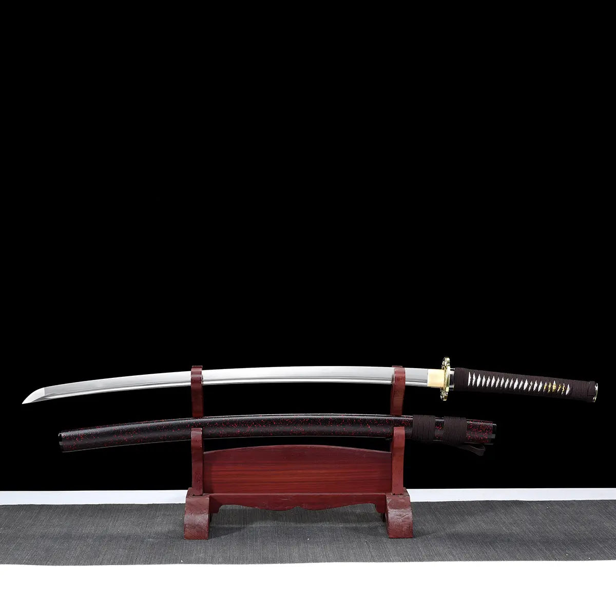 Unsheathed Ryusei Japanese katana displayed horizontally on a dark red wooden stand against a solid black background. The polished steel blade is fully visible, slightly curved, with a clean shinogi line and bohi running along the blade. The scabbard rests below the blade, showing a dark brown lacquered saya with black grain texture. The handle features dark brown cord wrapping over white ray skin panels, finished with a gold-colored dragon tsuba and matching habaki, highlighting the traditional mounting an