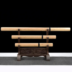 Set de tantō japonais shirasaya “San-Ken” présenté en trio (long, moyen, court) sur un support en bois sculpté à trois niveaux, fourreaux et poignées en bois clair avec bagues noires, fond noir studio et tapis gris — set artisanal en acier carbone 1045, polissage miroir, style minimaliste.