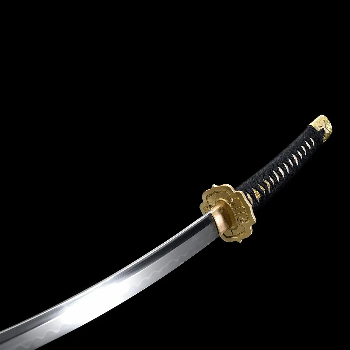 Japanese tachi katana Taiyo Taisho photographed on a deep black background, showing the curved polished steel blade with a visible natural hamon line near the cutting edge, paired with an ornate gold-colored tsuba and brass habaki, black tsuka wrapped in black ito over white ray skin panels with gold menuki, studio lighting highlighting the blade curvature, steel finish, and traditional Japanese fittings
