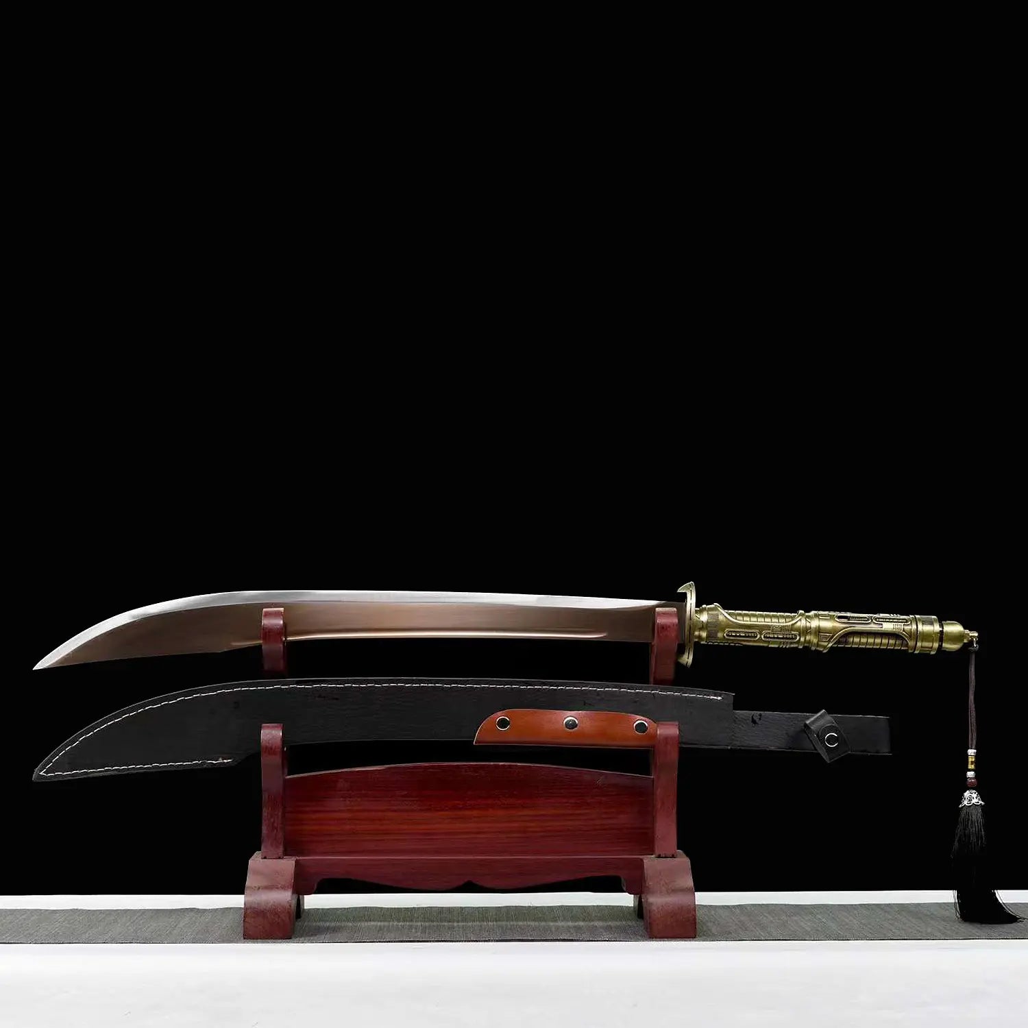 Sabre chinois Dao TIAN DAO présenté lame sortie au-dessus du fourreau noir courbe, avec poignée dorée rétro-futuriste, garde métallique, pompon noir suspendu, support en bois rouge et fond noir.