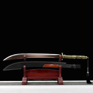 Sabre chinois Dao TIAN DAO présenté lame sortie au-dessus du fourreau noir courbe, avec poignée dorée rétro-futuriste, garde métallique, pompon noir suspendu, support en bois rouge et fond noir.