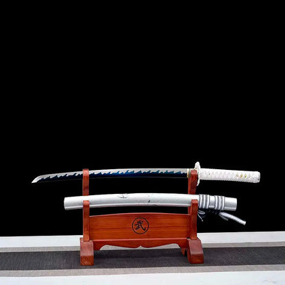Wakizashi Aonami Nishikigoi dégainé : lame acier 1060 polie main avec hamon ondulé bleu, saya argentée posée en dessous sur un support en bois verni, tsuka blanche, scène sur fond noir — katana japonais wakizashi motif koi, finition satinée.