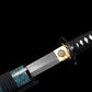 Sortie de saya du wakizashi japonais artisanal Aonami : lame T10 sans bohi avec hamon visible, habaki en laiton gravé, tsuba ronde noire, tsuka en ito noir à losanges de same blanche ; saya nashiji bleu-vert avec sageo noir, photographié sur fond noir.