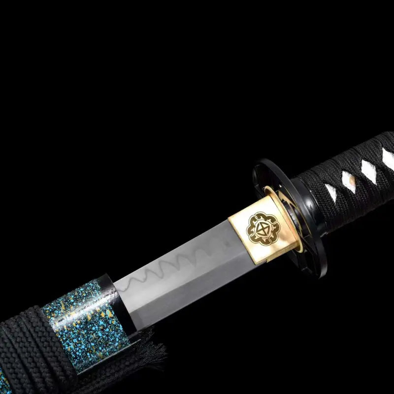 Sortie de saya du wakizashi japonais artisanal Aonami : lame T10 sans bohi avec hamon visible, habaki en laiton gravé, tsuba ronde noire, tsuka en ito noir à losanges de same blanche ; saya nashiji bleu-vert avec sageo noir, photographié sur fond noir.
