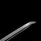 Gros plan de la pointe (kissaki) du wakizashi japonais “Kurochiku” : lame noire satinée avec bohi visible, tranchant poli, sur fond noir minimaliste.