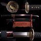 Composition de visuels du wakizashi japonais Renge no Reicha : gros plan tsuba lotus en laiton et habaki gravé, vue d’ensemble sur support en bois verni (support non inclus), saya noire laquée à liserés pourpres et lame acier plié damassé à patine sombre, fond noir studio — sabre court artisanal, Blade Bushido.
