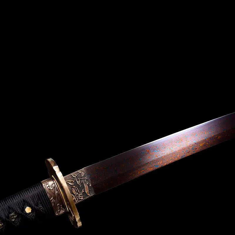 Gros plan du wakizashi japonais Renge no Reicha : lame acier plié damassé aux reflets brun-rouge, patine sombre, habaki gravé de feuilles, tsuba en laiton motif lotus, tsuka tressé noir, éclairage latéral sur fond noir — sabre court artisanal Blade Bushido.