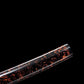 Gros plan du saya d’un wakizashi shirasaya artisanal Kuro Yōgan, laque urushi noir-vermillon (effet kawari-nuri “lave”), cadré en diagonale sur fond noir, brillance de finition bien visible ; détail du fourreau sans support, ambiance studio premium.