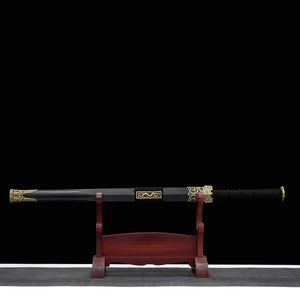Épée chinoise Jian XUAN LONG présentée dans son fourreau noir sur support en bois brun, avec poignée noire tressée, garnitures dorées, plaque dragon et fond noir sobre.