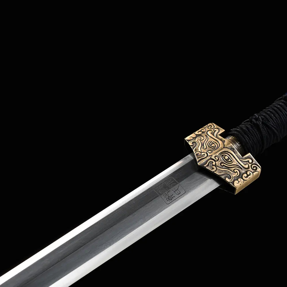 Gros plan sur l’épée chinoise Jian XUAN LONG, avec lame droite gravée de caractères chinois, garde dorée à motifs traditionnels, poignée noire tressée et fond noir sobre.