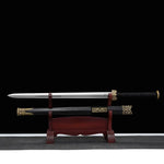 Épée chinoise Jian XUAN LONG présentée sur support en bois brun, avec lame droite sortie du fourreau noir, poignée noire tressée, garde dorée décorée et garnitures métalliques à motifs dragon.