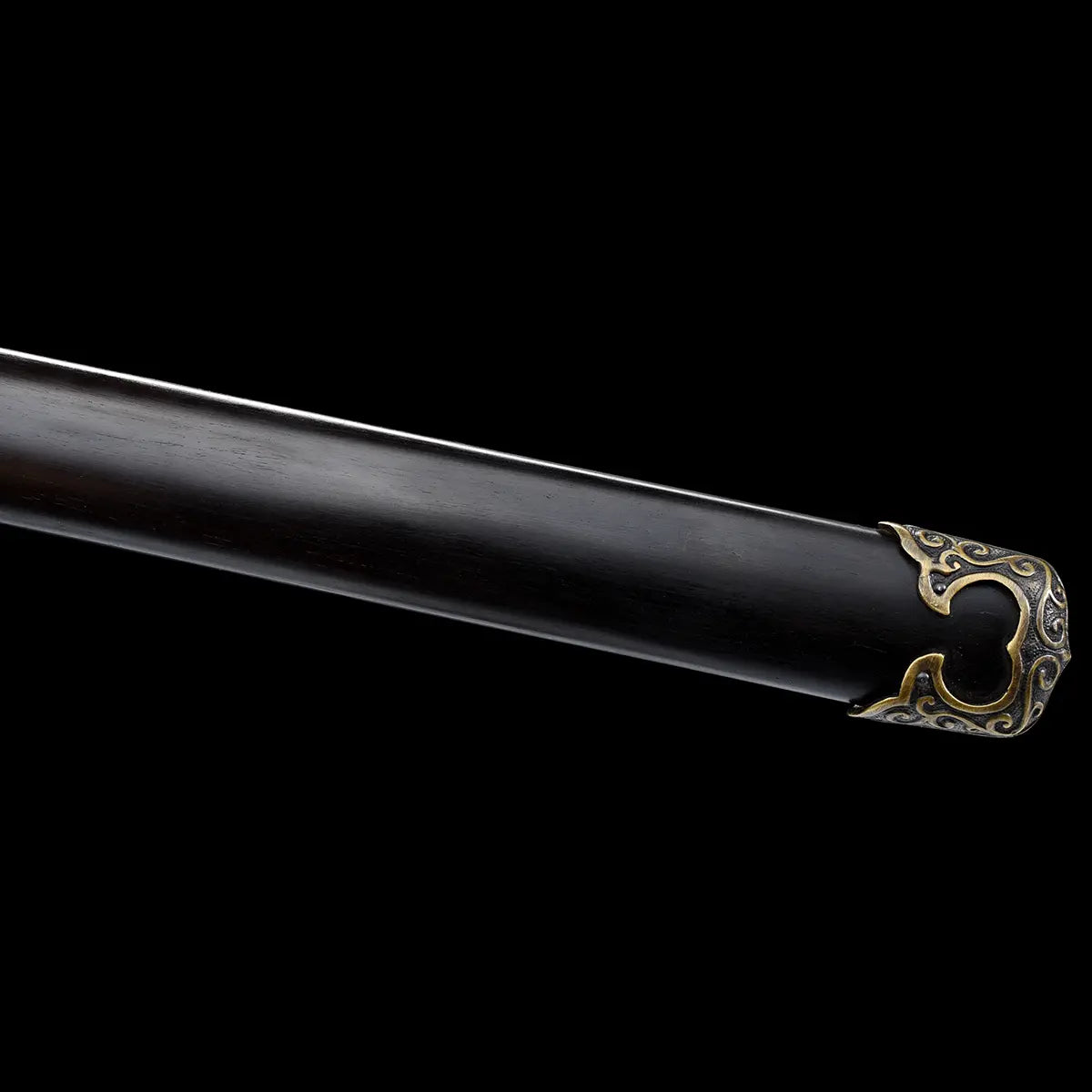 Gros plan sur l’extrémité du fourreau noir laqué d’une épée chinoise Jian YI XIN, avec garniture métallique décorative en laiton vieilli sur fond noir. L’image met en valeur la finition sombre du fourreau, la texture du bois laqué et les ornements traditionnels de ce Jian chinois artisanal de collection.