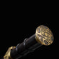 Gros plan sur le pommeau bronze ancien de l’épée chinoise Jian ZHEN ZHAI, avec motifs géométriques gravés, poignée noire en ébène et finition sombre sur fond noir.
